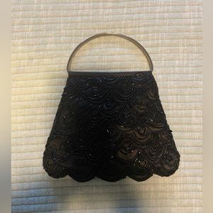 Small black beaded evening purse with silver handles.  Excellent condition.